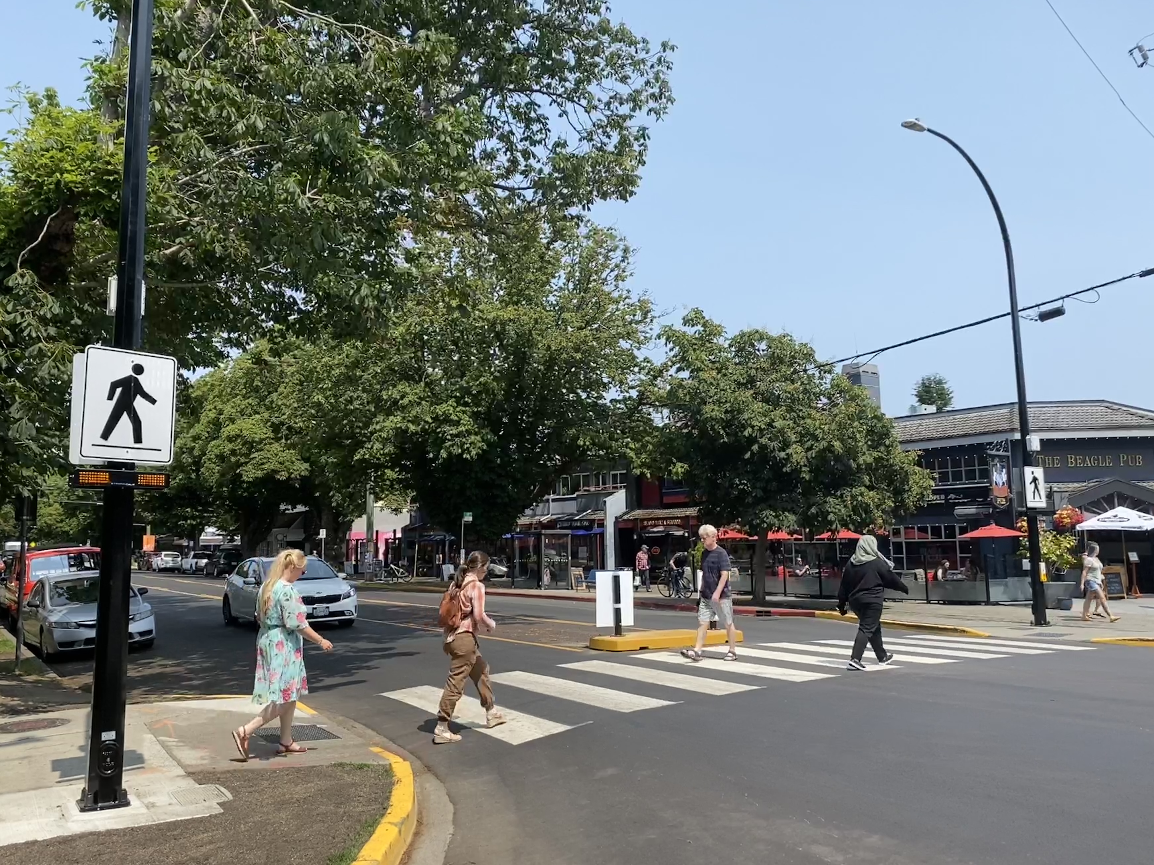 city residents using a cross walk in the summer