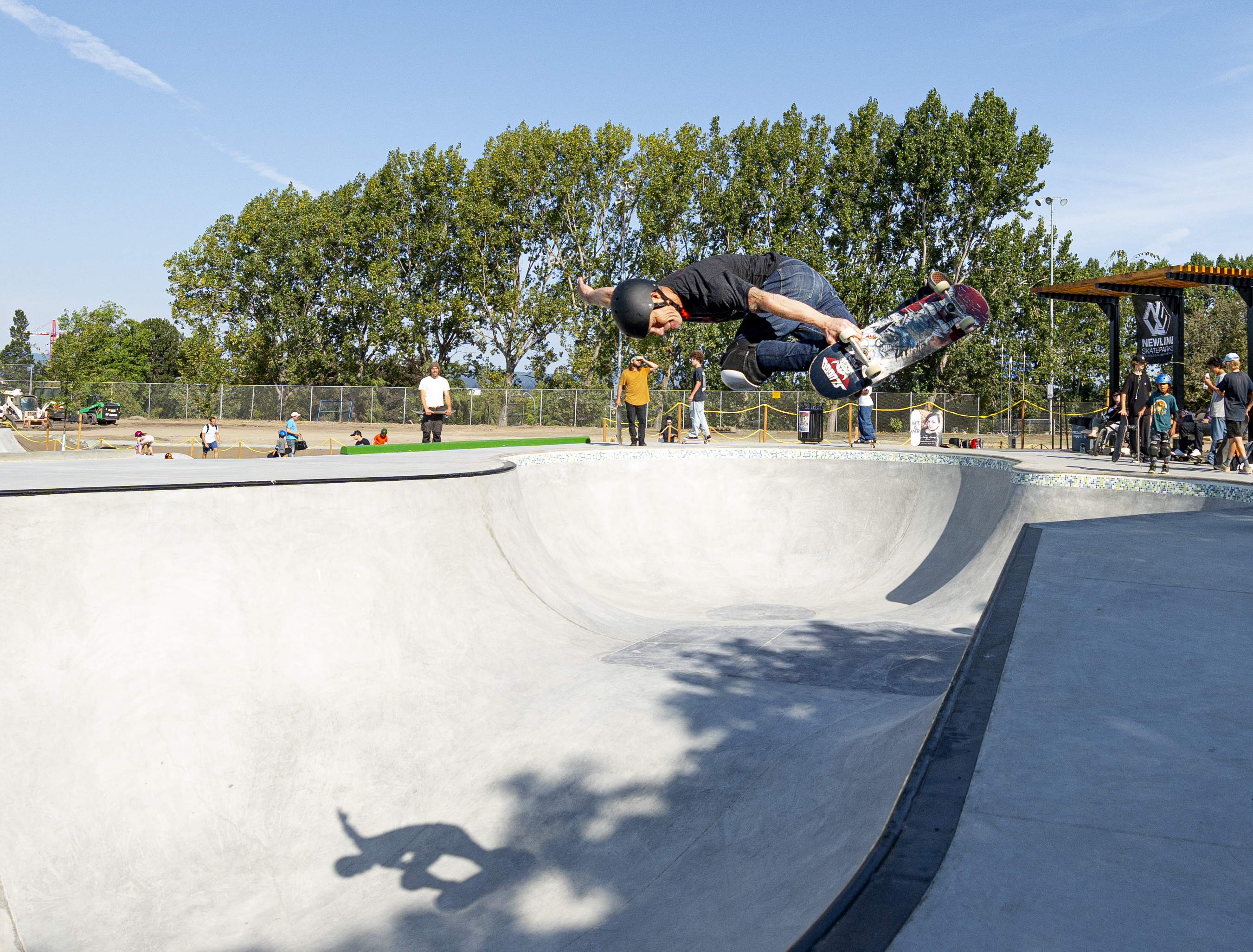 a skateboarding in a bowl at a skatepark ollying 