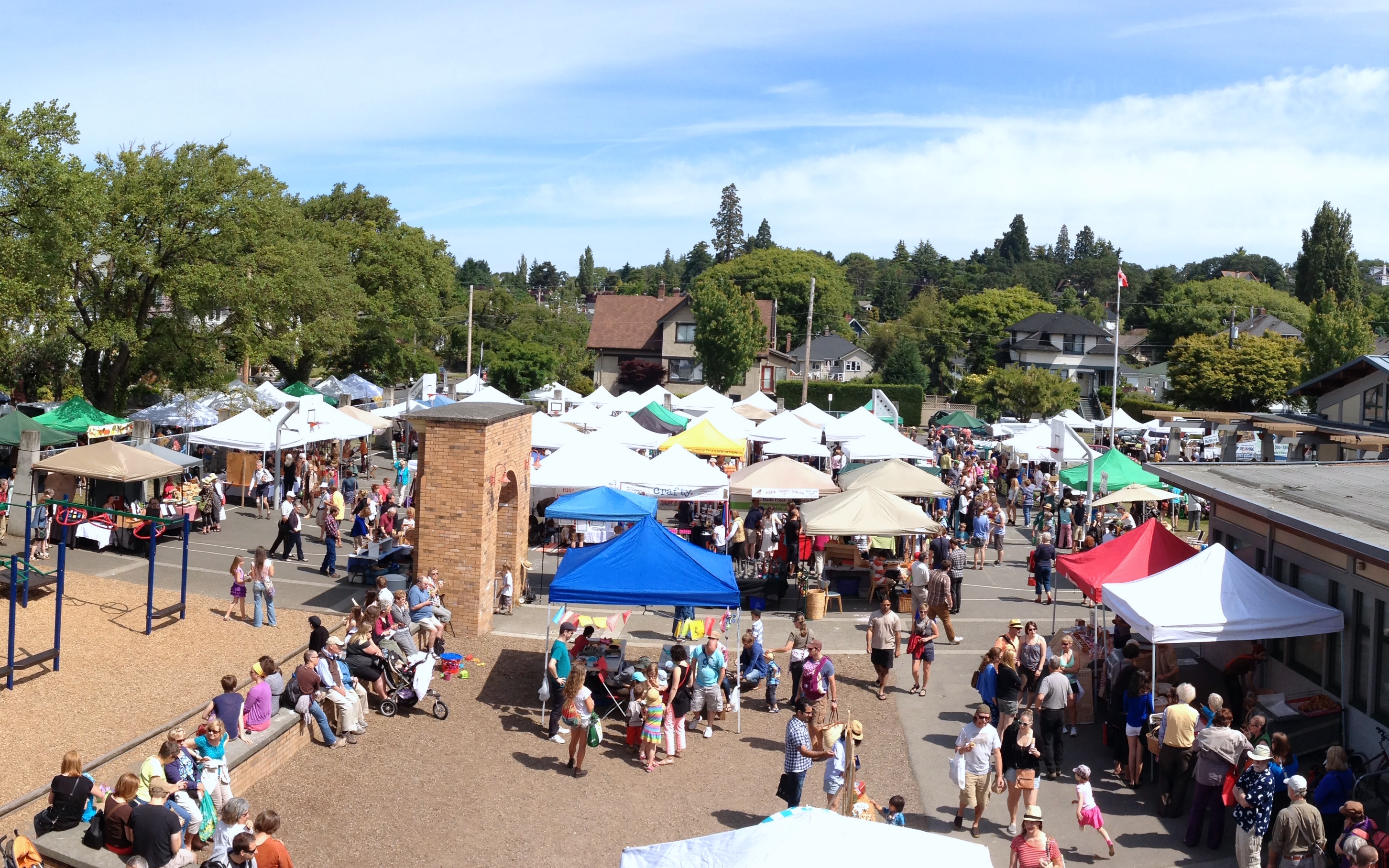 a summer marketing in the city with lots of vendors under umbrellas